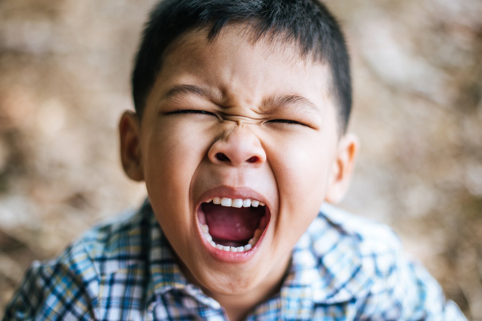 close-up-young-boy-yelling-with-mouth-open