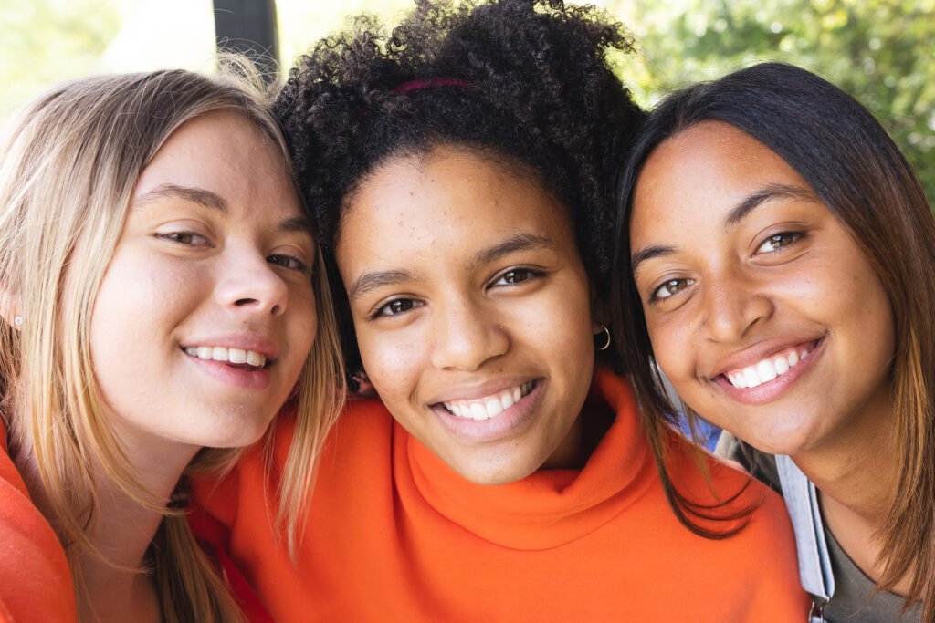 three smiling young women in outdoor setting